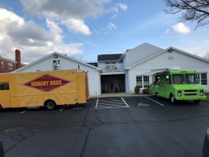 Two food trucks outside of art gallery
