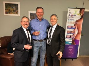 Three men smiling for camera at charity event