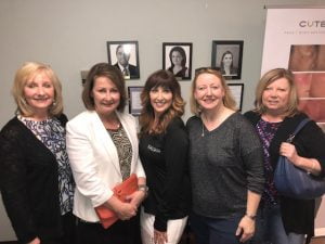 Five group of women posing for camera and smiling at charity event