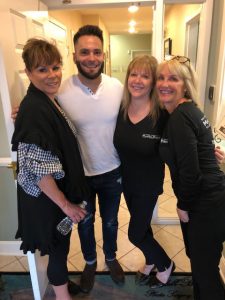 Four people posing and smiling for camera at charity event