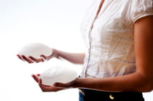 safety of silicone gel breast implants, woman holding implants