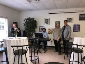 Dr. Mandell-Brown and musicians smiling at charity event