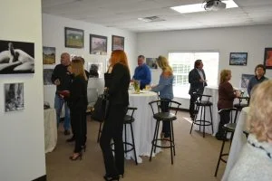 Group of people standing around in art gallery