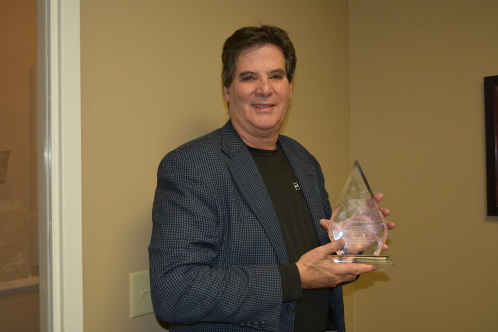 Dr. Mandell-Brown smiling, holding the Webster Award
