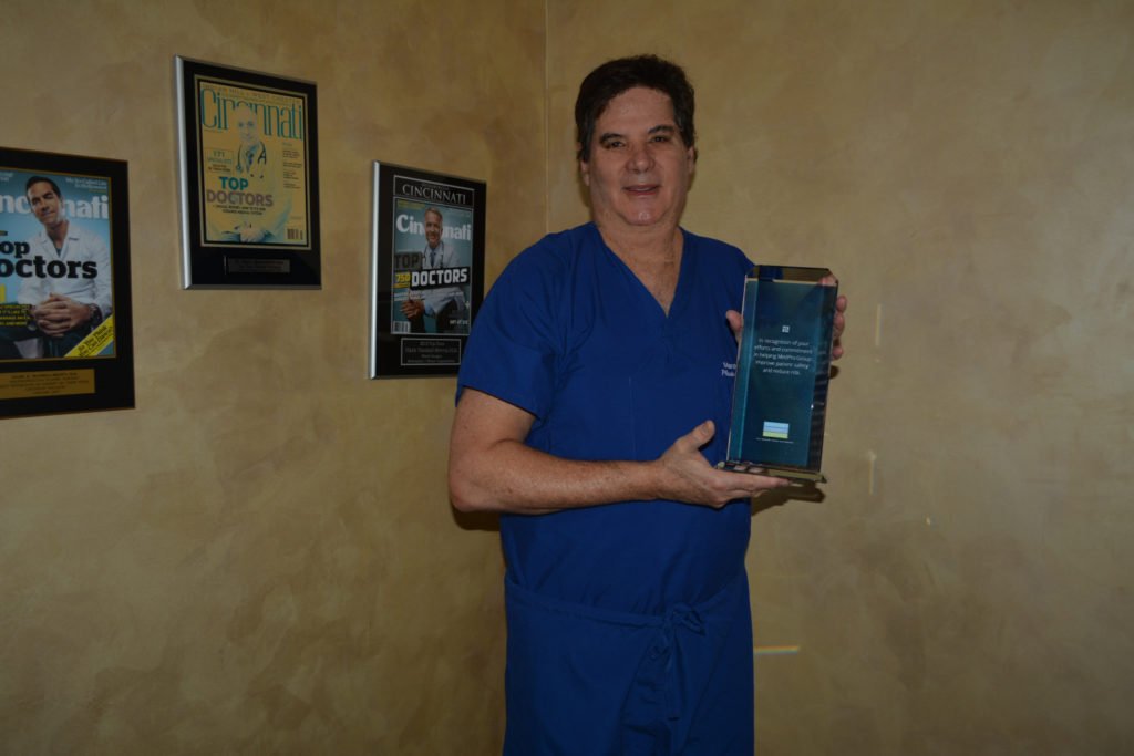 Dr. Mandell-Brown smiling, holding the MedPro Insurance Safety Award