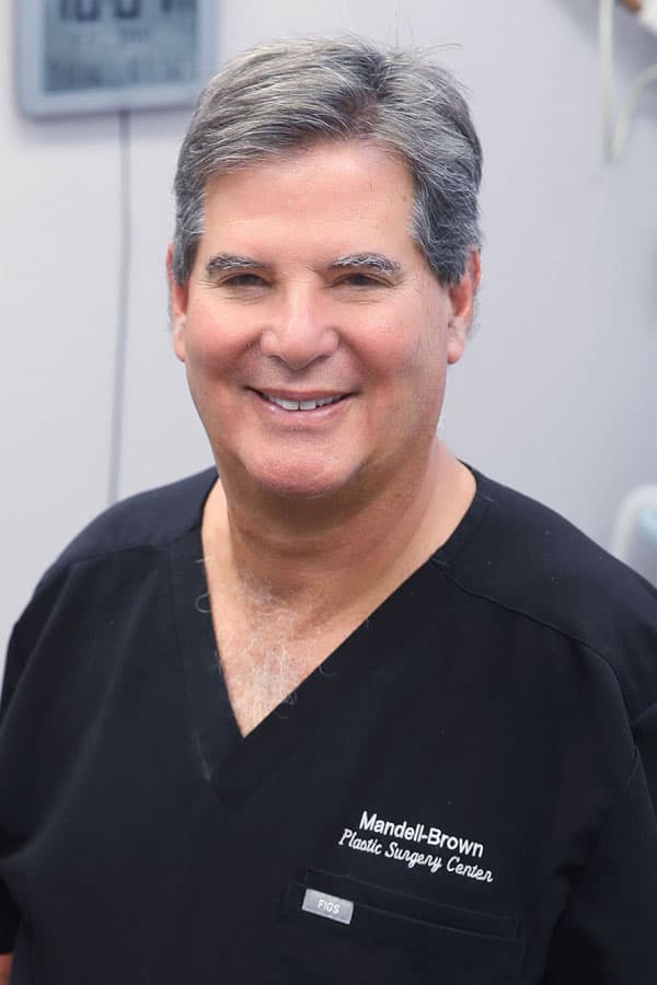 Portrait of Dr. Mandell-Brown smiling wearing black scrubs