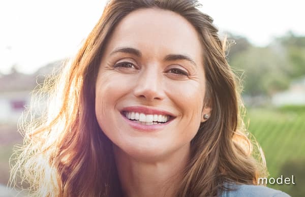 Brow Lift model of woman smiling directly at camera outside