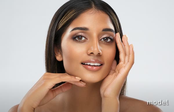 Diamond Glow model of woman posing for camera with hands around face