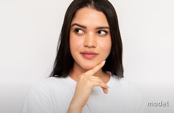 Kybella Double Chin Reduction model of woman looking away from camera touching chin