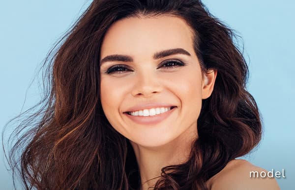 Quick Facelift model of woman looking at camera smiling against blue background