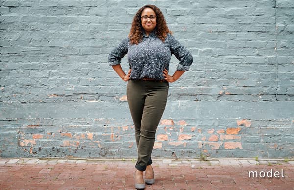 Thighplasty (Thigh Lift) woman standing in front of brick wall posing with hands on hips