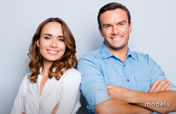 Facial Implants models of man and woman with arms crossed smiling and posing for camera
