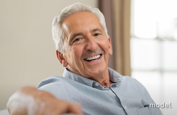 Skin Cancer Reconstruction model of elderly man sitting on couch smiling at camera