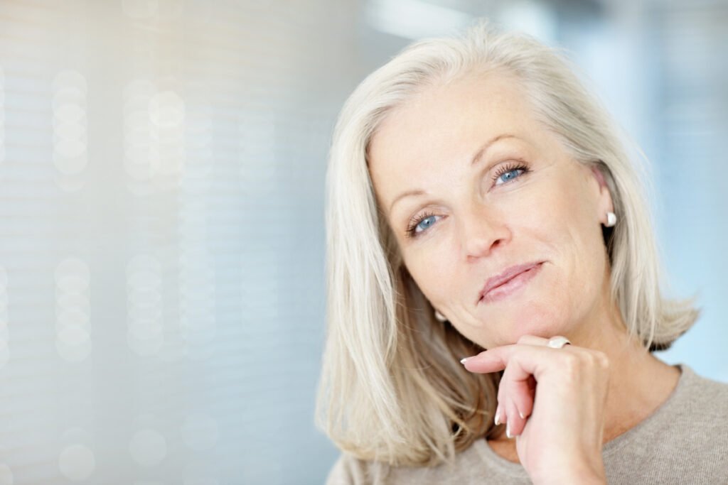 Mature woman with hand under chin