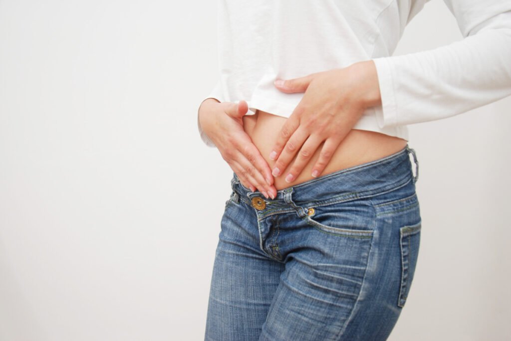 Woman with hands over abdominal muscles