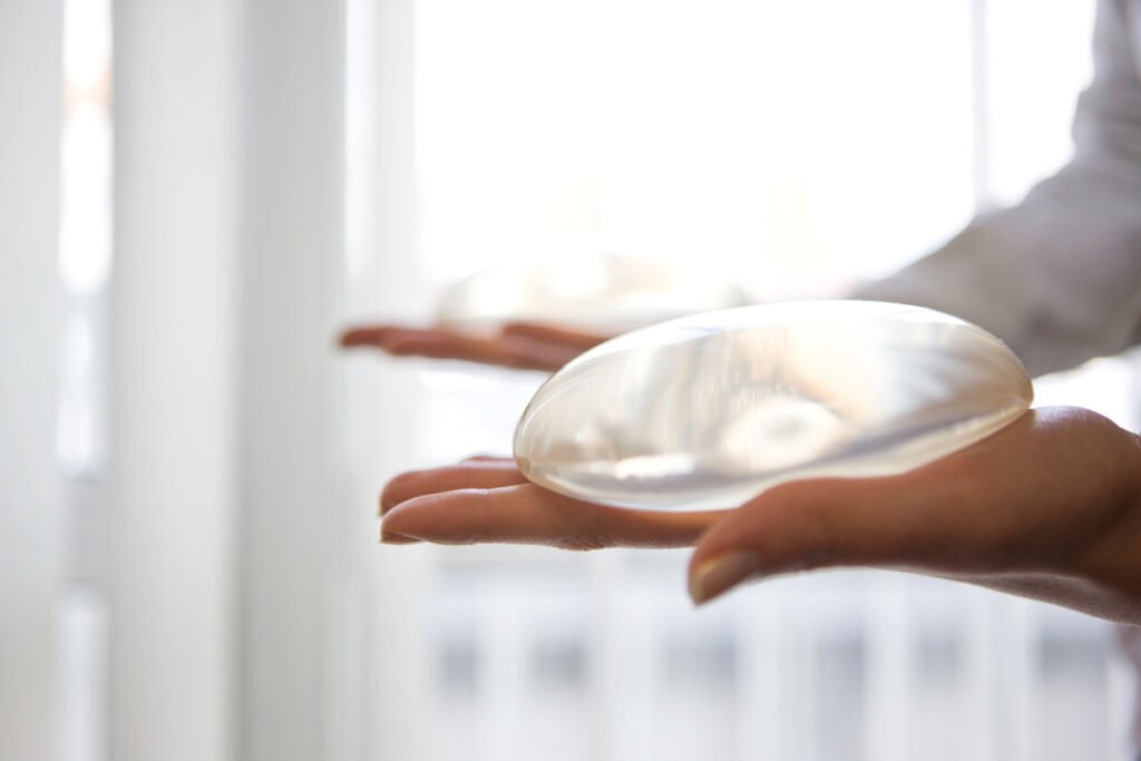 Woman holding two breast implants