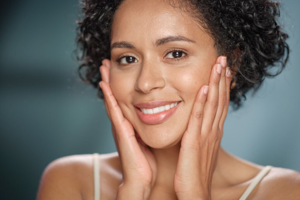 Mature woman touching face after cosmetic treatments to restore volume and fullness