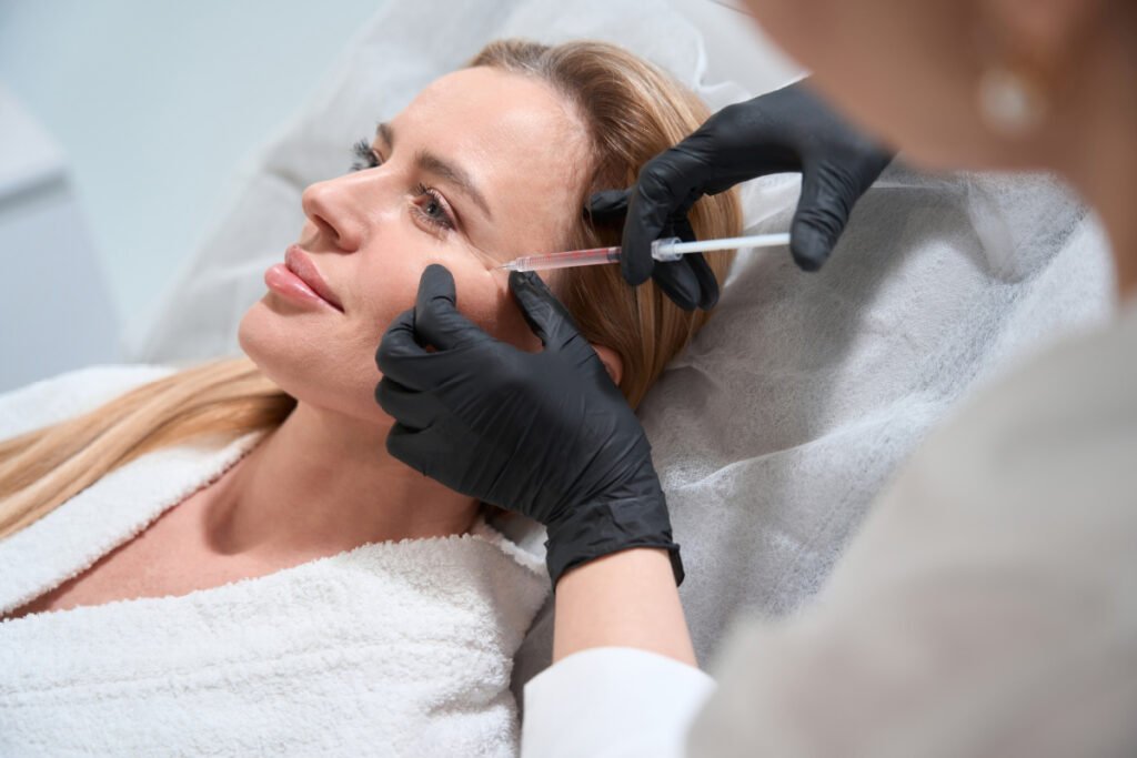 Woman getting dermal filler injections to add volume to cheeks
